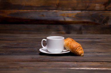 Kahve ve çörek ahşap arka plan üzerinde beyaz fincan