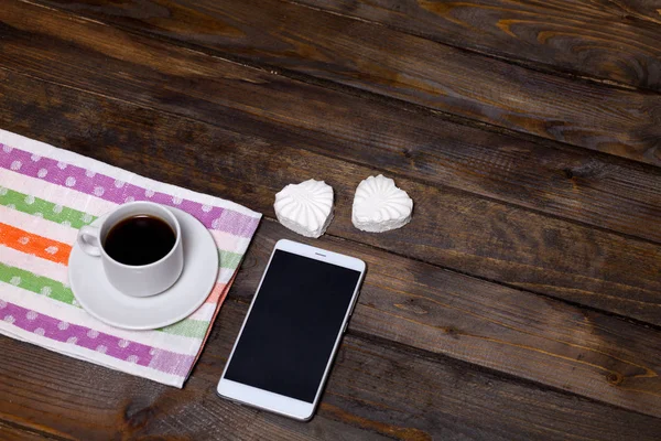 Caneca branca de café e dois marshmallows na forma de corações em um fundo de madeira para o café da manhã — Fotografia de Stock