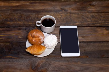 Kahve beyaz Kupası ve cep telefonu kruvasan, pasta, şekerleme