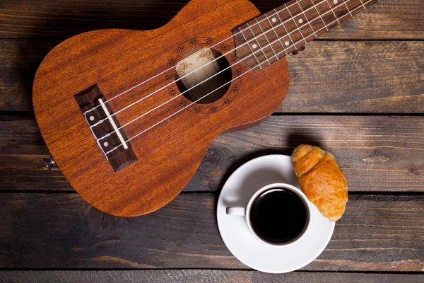 Ukulele ukulele fincan kahve ve kruvasan ile