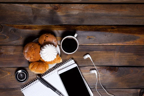 Lente de câmera com croissants e café ao lado do notebook — Fotografia de Stock