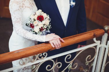 Gelin ve damat yavaşça düğünde, merdivenlerde, ayakta eller yakın çekim