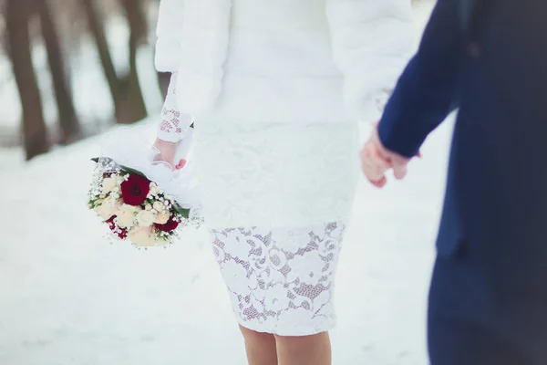 Pengantin wanita dan pengantin pria yang lembut berpegangan tangan di pernikahan, close-up di musim dingin — Stok Foto