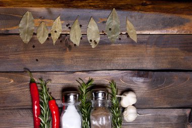 Defne yaprağı ve kırmızı biber biber, ahşap, en iyi görünümü çalışma alanının arka plan üzerinde beyaz sarımsak ile tuz ve biber Çalkalayıcı