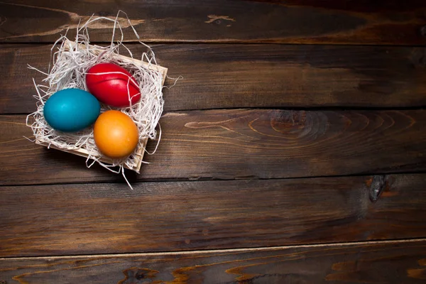 木製の背景にティンセルを持つボックスで複数の色、明るいイースターの卵 — ストック写真