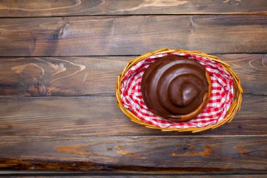 Ahşap arka plan üzerinde bir hasır sepet içinde çikolata lezzetli, taze simit