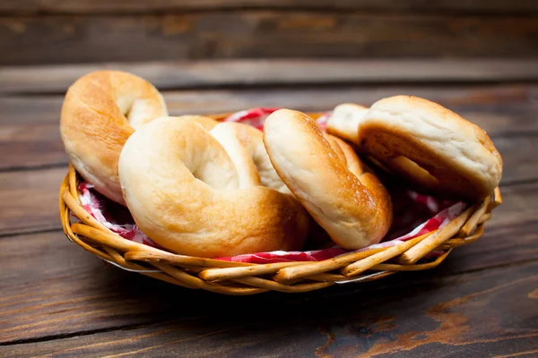 Délicieux bretzels frais dans un panier en osier sur fond de bois — Photo