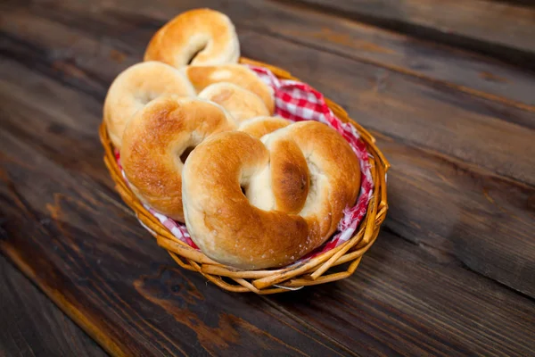 Deliciosos, pretzels frescos em cesta de vime no fundo de madeira — Fotografia de Stock