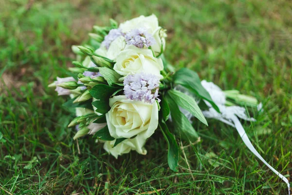 Beautiful bridal bouquet of the bride on the green grass — Stock Photo, Image