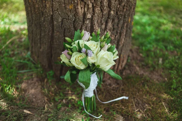 Beautiful bridal bouquet of a bride near a tree — Stock Photo, Image