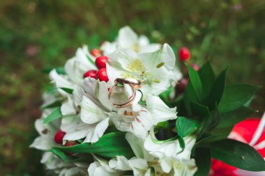 Yakın çekim yaz yeşil çim üzerinde gelin düğün buket güzel altın alyans