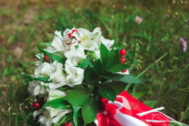 Yakın çekim yaz yeşil çim üzerinde gelin düğün buket güzel altın alyans