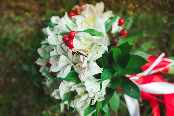 Yakın çekim yaz yeşil çim üzerinde gelin düğün buket güzel altın alyans