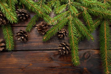 Yeşil çam dalları koyu ahşap arka plan üzerinde yaşayan. Yeni yıl arka plan koniler ile. Üstten Görünüm