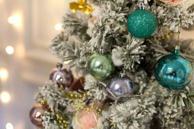 Yeni yıl yapay Noel ağacı hafif bulanık bir arka plan üzerinde renkli parlak topları ile dekore edilmiştir. Noel arka plan