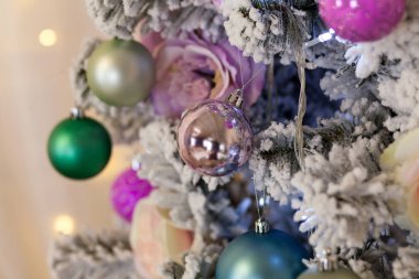 Yeni yıl yapay Noel ağacı hafif bulanık bir arka plan üzerinde renkli parlak topları ile dekore edilmiştir. Noel arka plan