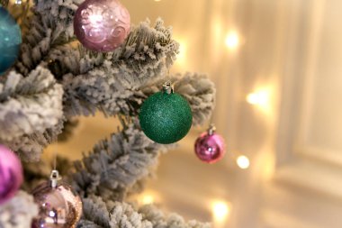 Yeni yıl yapay Noel ağacı hafif bulanık bir arka plan üzerinde renkli parlak topları ile dekore edilmiştir. Noel arka plan