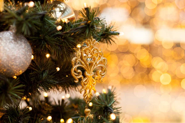 Yeşil Ladin üzerinde Noel süsleri. Yeni yıl topları ve çelenk bir sarı arka plan bulanık, bokeh üzerindeki sembolleri