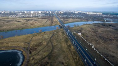 Fotoğraf bir asfalt yol ile şehrin. Manzara bir yükseklikten fotoğraflandı. Bir köprü ve bir nehir