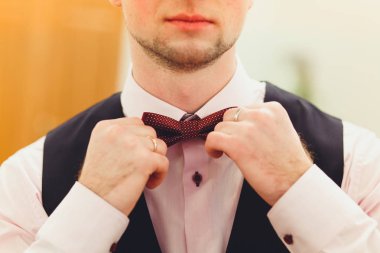 Her iki el ile takım elbiseli bir adam kelebek ayarlar. Damat Düğün