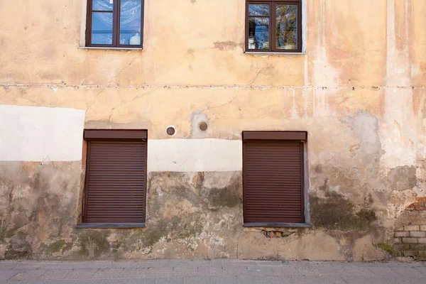 Closed windows and open windows in the old building on a sunny day.