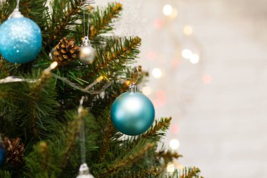 Toplar ve çelenklerle süslenmiş güzel yeşil Noel ağacı. Yakın plan fotoğraf. Parlak arkaplan