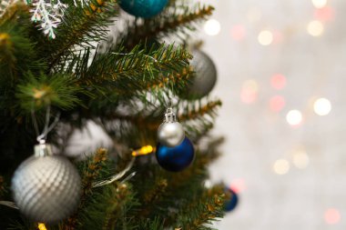 Toplar ve çelenklerle süslenmiş güzel yeşil Noel ağacı. Yakın plan fotoğraf. Parlak arkaplan
