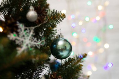 Toplar ve çelenklerle süslenmiş güzel yeşil Noel ağacı. Yakın plan fotoğraf. Parlak arkaplan