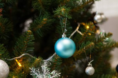 Toplar ve çelenklerle süslenmiş güzel yeşil Noel ağacı. Yakın plan fotoğraf.