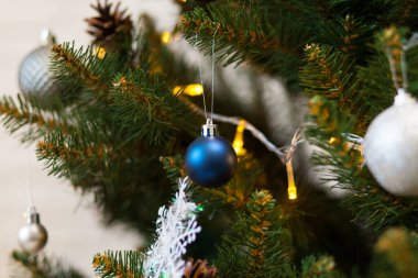 Toplar ve çelenklerle süslenmiş güzel yeşil Noel ağacı. Yakın plan fotoğraf.