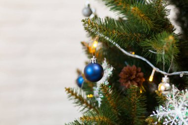 Toplar ve çelenklerle süslenmiş güzel yeşil Noel ağacı. Yakın plan fotoğraf.