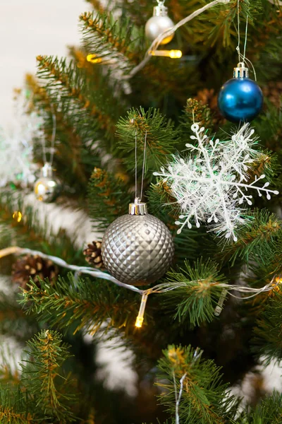 Toplar ve çelenklerle süslenmiş güzel yeşil Noel ağacı. Yakın plan dikey fotoğraf — Stok fotoğraf