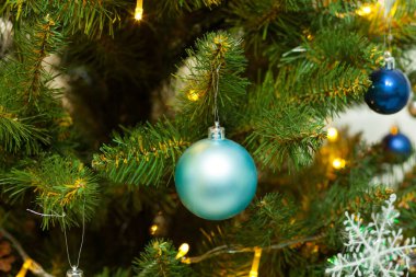Toplar ve çelenklerle süslenmiş güzel yeşil Noel ağacı. Yakın plan fotoğraf.