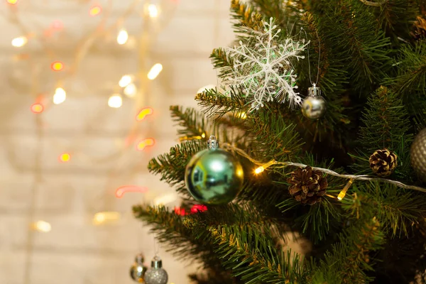 Toplar ve çelenklerle süslenmiş güzel yeşil Noel ağacı. Yakın plan fotoğraf. Parlak arkaplan — Stok fotoğraf