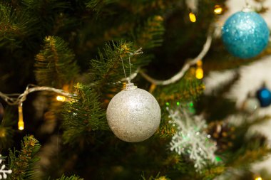 Toplar ve çelenklerle süslenmiş güzel yeşil Noel ağacı. Yakın plan fotoğraf.