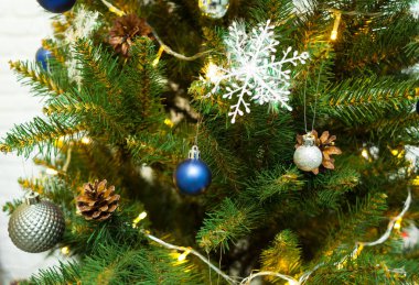 Toplar ve çelenklerle süslenmiş güzel yeşil Noel ağacı. Yakın plan fotoğraf.