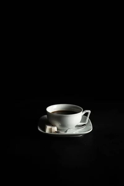 Cafea și zahăr în cupe albe cu farfurie pe fundal negru — Fotografie, imagine de stoc