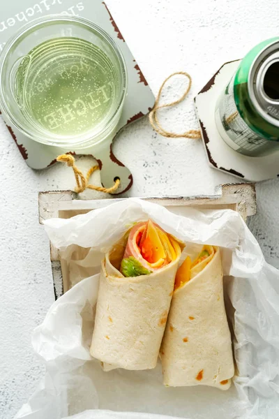 Wrap-Sandwich mit Schinken, Käse und Gemüse, Dose Soda, Glas mit Getränk auf weißem Hintergrund, Nahaufnahme — Stockfoto