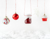 Vánoční hračky, červené ovoce džem ve skleněné sklenici visí na bílém pozadí