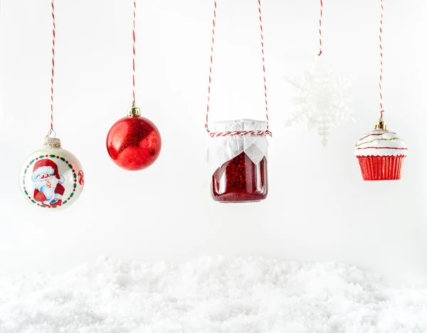 Zabawki świąteczne, czerwony dżem owocowy w szklanym słoiku wiszącym na białym tle — Zdjęcie stockowe