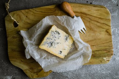 Tahtada peynir dilimi, peynir bıçağıyla.