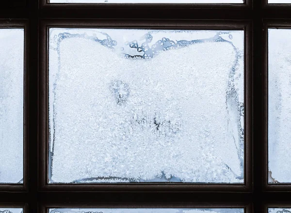 Frost patterns on window glass framed with dark wood — Stock Photo, Image