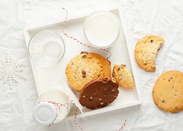 Selectarea cookie-urilor de casă, lapte, decor de iarnă pe tava de lemn fundal alb, vedere de sus — Fotografie, imagine de stoc