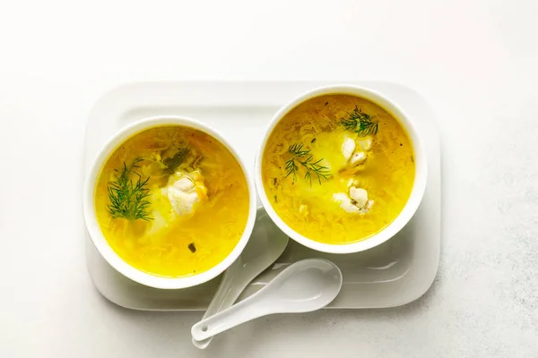 Homemade pasta chicken soup served in bowls on a white tray on white background — 스톡 사진