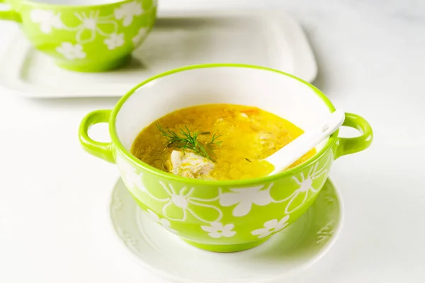 Homemade pasta chicken soup served in a light green bowl on a white tray on white background — 스톡 사진