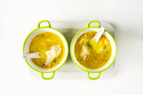 Pasta buatan sendiri sup ayam dalam mangkuk hijau muda pada nampan putih di latar belakang putih, atas tampilan — Stok Foto