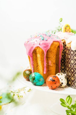Geleneksel jöleli Paskalya pastaları, renkli yumurtalar ve beyaz arka planda dekorasyon.