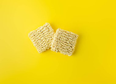 Canlı sarı arka planda iki kuru erişte bloğu. Düz Düzen