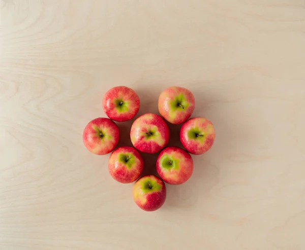 粉红女士的苹果在木制背景上。心形布局 — 图库照片