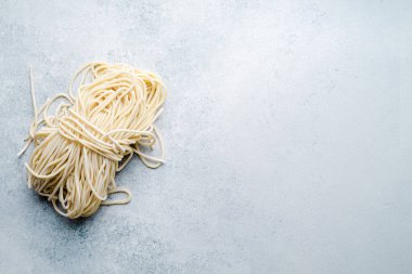 Uncooked fresh pasta on light blue background